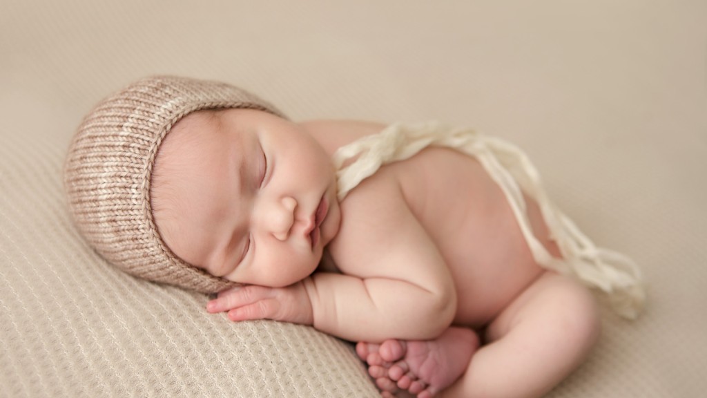 Simple and sweet baby girl newborn photography session in San Marcos, Ca. Posed on a cream colored fabric and a beautiful bonnet added for style.