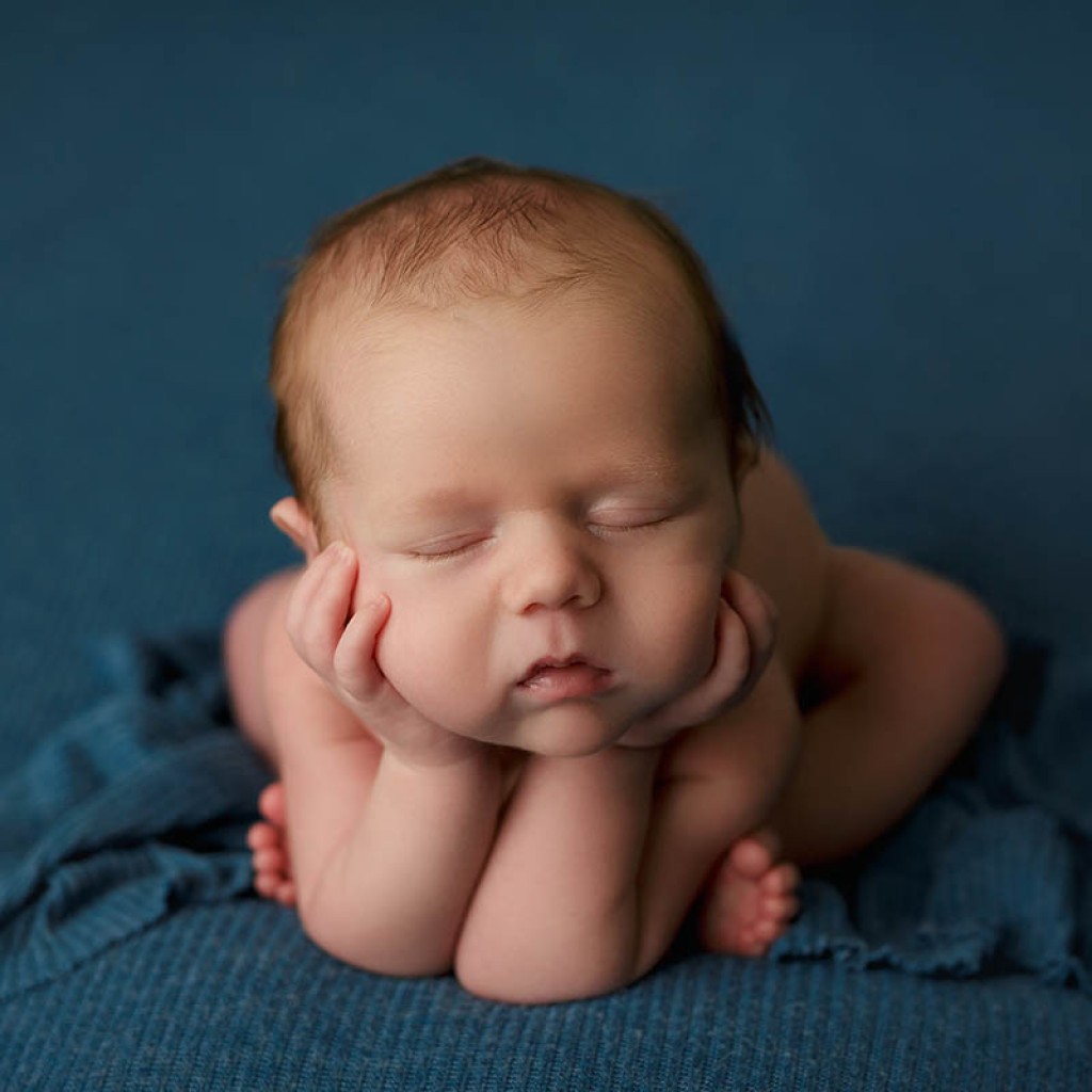 blue cherub pose also known as the froggy pose. This is a trick of photoshop, the baby has hands grown-up hands supporting it at all times.