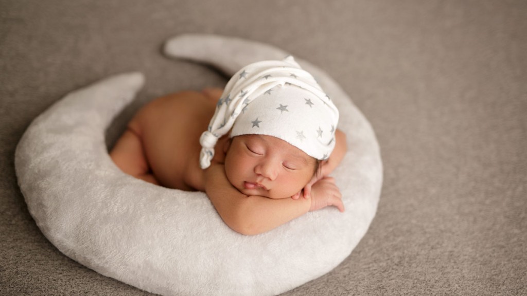 Cute baby boy in a special stars sleepy hat, posed on a moon pillow. San diego newborn photographer Shelly Rosen created this image in her san marcos newborn photography studio.